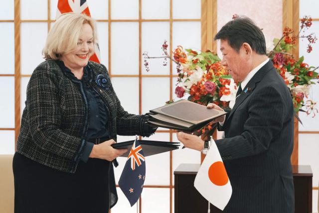 Japan's Foreign Minister Toshimitsu Motegi (R) shakes hands with New Zealand's Defence Minister Judith Collins at the signing of the Japan-New Zealand Acquisition and Cross-Servicing Agreement and the Japan-New Zealand Information Security Agreement, at the Foreign Ministry in Tokyo on December 19, 2025. (Photo by Kazuhiro NOGI / AFP)