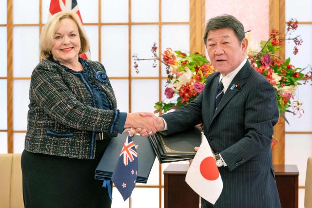 Japan's Foreign Minister Toshimitsu Motegi (R) shakes hands with New Zealand's Defence Minister Judith Collins at the signing of the Japan-New Zealand Acquisition and Cross-Servicing Agreement and the Japan-New Zealand Information Security Agreement, at the Foreign Ministry in Tokyo on December 19, 2025. (Photo by Kazuhiro NOGI / AFP)