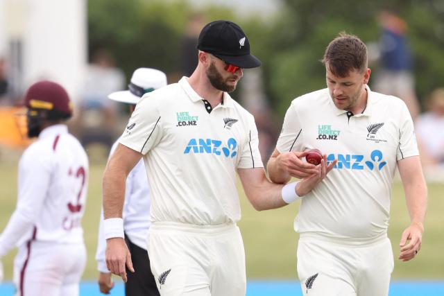 New Zealand’s Michael Rae (L) gives the ball to Jacob Duffy during day two of the 3rd international Test cricket match between New Zealand and West Indies at Bay Oval in Mount Maunganui on December 19, 2025. (Photo by Michael Bradley / AFP)