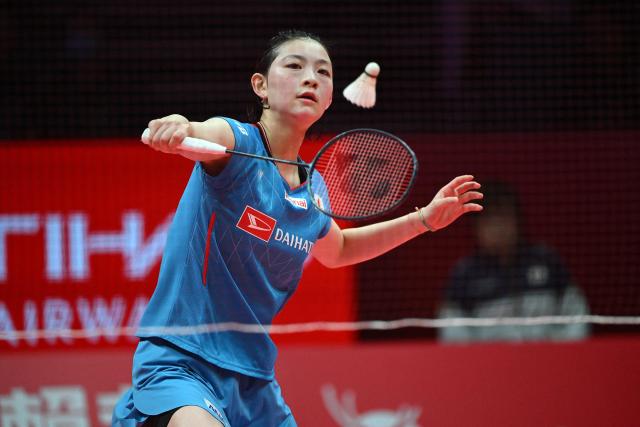 Japan’s Tomoka Miyazaki hits a return to Indonesia’s Putri Kusuma Wardani during their women's singles match at the BWF Badminton World Tour Finals at the Hangzhou Olympic Sports Centre Gymnasium in Hangzhou, in eastern China's Zhejiang province on December 19, 2025. (Photo by Jade Gao / AFP)
