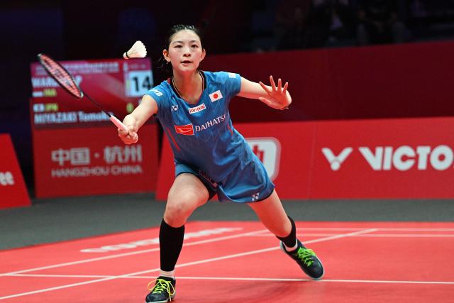 Japan’s Tomoka Miyazaki hits a return to Indonesia’s Putri Kusuma Wardani during their women's singles match at the BWF Badminton World Tour Finals at the Hangzhou Olympic Sports Centre Gymnasium in Hangzhou, in eastern China's Zhejiang province on December 19, 2025. (Photo by Jade Gao / AFP)