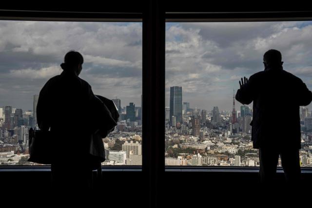 People visit an observatory deck in Tokyo on December 19, 2025. (Photo by Yuichi YAMAZAKI / AFP)