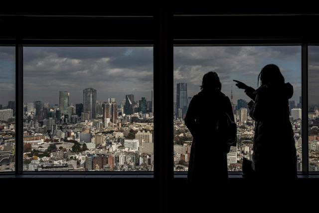 People visit an observatory deck in Tokyo on December 19, 2025. (Photo by Yuichi YAMAZAKI / AFP)