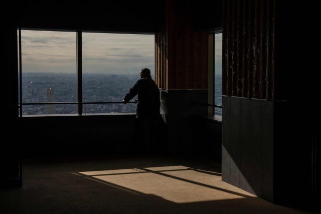A man visits an observatory deck in Tokyo on December 19, 2025. (Photo by Yuichi YAMAZAKI / AFP)