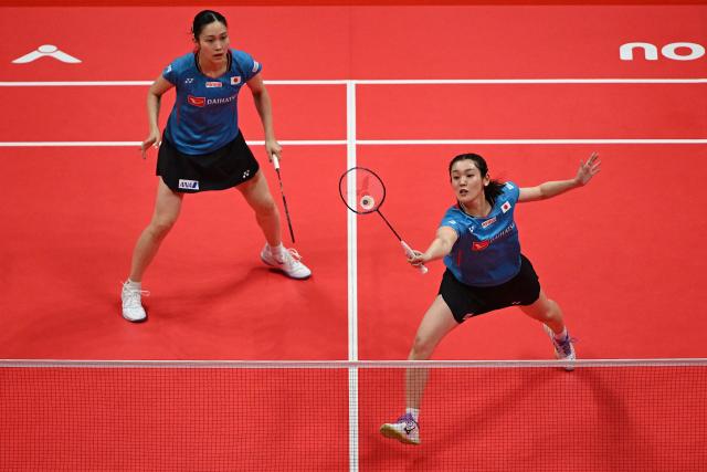 Japan’s Rin Iwanaga (R) and Kie Nakanishi play a point during their women's doubles match against China’s Jia Yifan and Zhang Shuxian at the BWF Badminton World Tour Finals at the Hangzhou Olympic Sports Centre Gymnasium in Hangzhou, in eastern China's Zhejiang province on December 19, 2025. (Photo by Jade Gao / AFP)