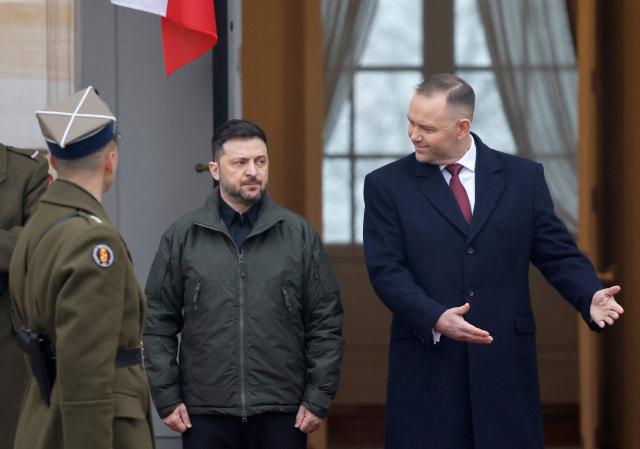 Poland's President Karol Nawrocki (R) and Ukraine's President Volodymyr Zelensky attend a welcome ceremony prior to talks at the Presidential Palace in Warsaw, Poland, on December 19, 2025. (Photo by Wojtek RADWANSKI / AFP)