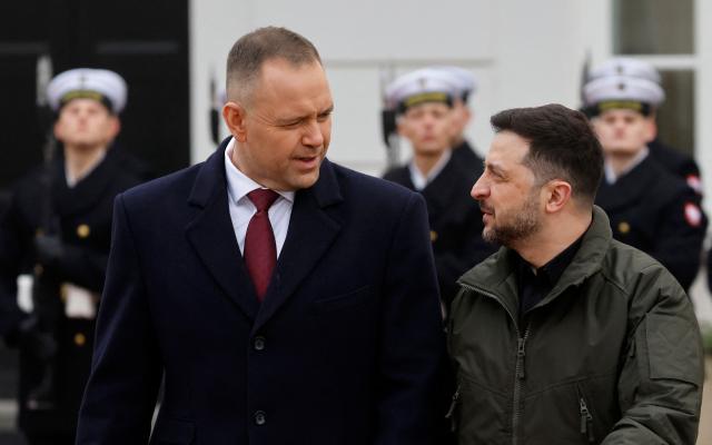 Poland's President Karol Nawrocki (L) and Ukraine's President Volodymyr Zelensky review a military honor guard during a welcome ceremony prior to talks at the Presidential Palace in Warsaw, Poland, on December 19, 2025. (Photo by Wojtek RADWANSKI / AFP)