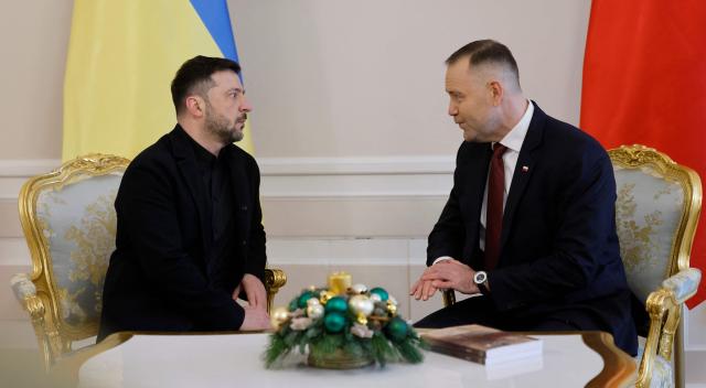 Poland's President Karol Nawrocki (R) and Ukraine's President Volodymyr Zelensky have taken seat for talks at the Presidential Palace in Warsaw, Poland, on December 19, 2025. (Photo by Wojtek RADWANSKI / AFP)