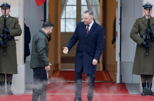 Poland's President Karol Nawrocki (C-R) welcomes Ukraine's President Volodymyr Zelensky (C-L) as he arrives for talks at the Presidential Palace in Warsaw, Poland, on December 19, 2025. (Photo by Wojtek RADWANSKI / AFP)