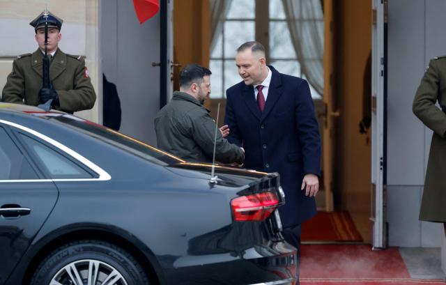 Poland's President Karol Nawrocki (C-R) welcomes Ukraine's President Volodymyr Zelensky (C-L) as he arrives for talks at the Presidential Palace in Warsaw, Poland, on December 19, 2025. (Photo by Wojtek RADWANSKI / AFP)