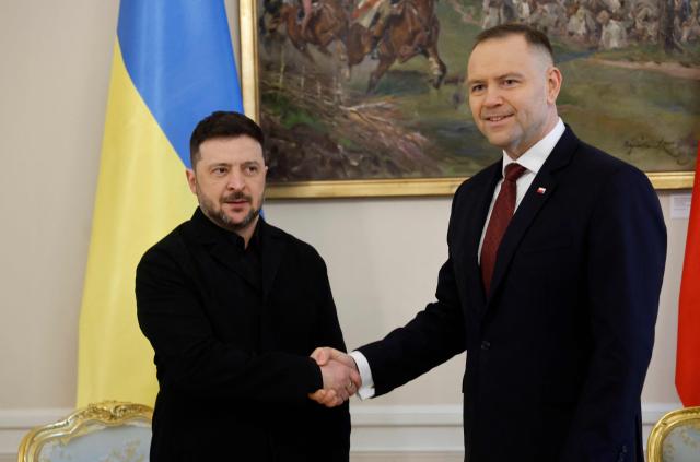 Poland's President Karol Nawrocki (R) and Ukraine's President Volodymyr Zelensky shake hands prior to talks at the Presidential Palace in Warsaw, Poland, on December 19, 2025. (Photo by Wojtek RADWANSKI / AFP)