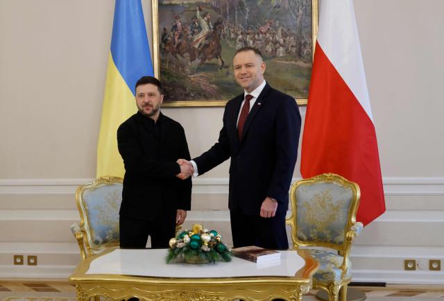 Poland's President Karol Nawrocki (R) and Ukraine's President Volodymyr Zelensky shake hands prior to talks at the Presidential Palace in Warsaw, Poland, on December 19, 2025. (Photo by Wojtek RADWANSKI / AFP)