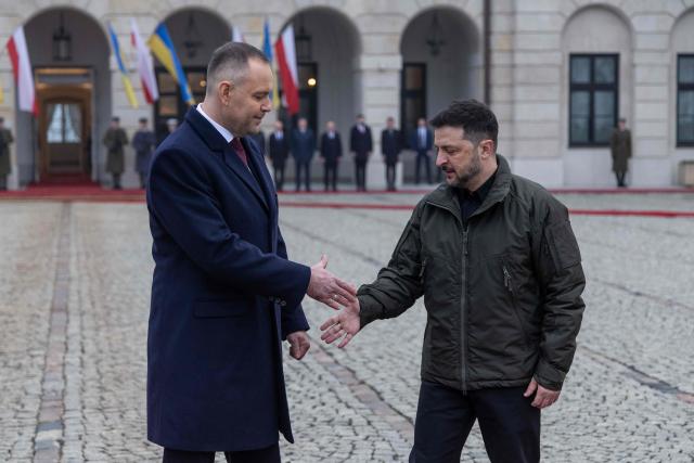Poland's President Karol Nawrocki (L) and Ukraine's President Volodymyr Zelensky (R) shake hands during a welcome ceremony prior to talks at the Presidential Palace in Warsaw, Poland, on December 19, 2025. (Photo by Wojtek RADWANSKI / AFP)