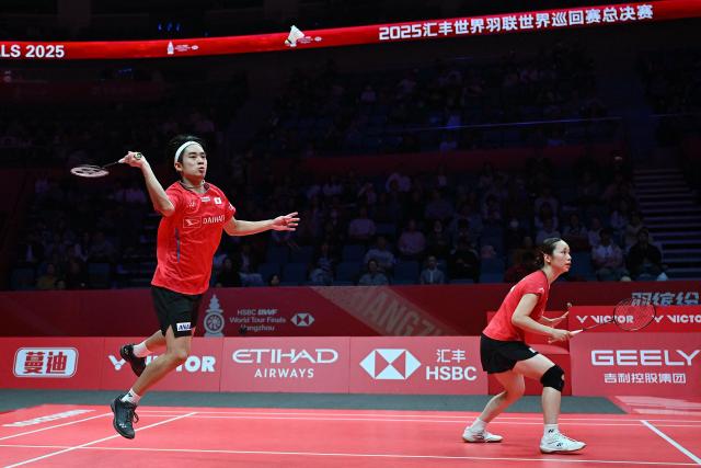 Japan’s Hiroki Midorikawa (L) and Natsu Saito play a point during their mixed doubles match against France’s Thom Gicquel and Delphine Delrue at the BWF Badminton World Tour Finals at the Hangzhou Olympic Sports Centre Gymnasium in Hangzhou, in eastern China's Zhejiang province on December 19, 2025. (Photo by Jade Gao / AFP)