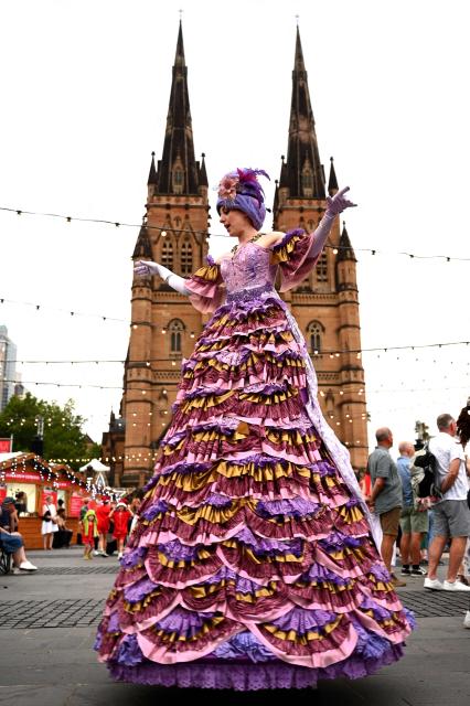 An artist performs for visitors at St. Mary’s Cathedral during Christmas festivities in Sydney on December 19, 2025. (Photo by Saeed KHAN / AFP)