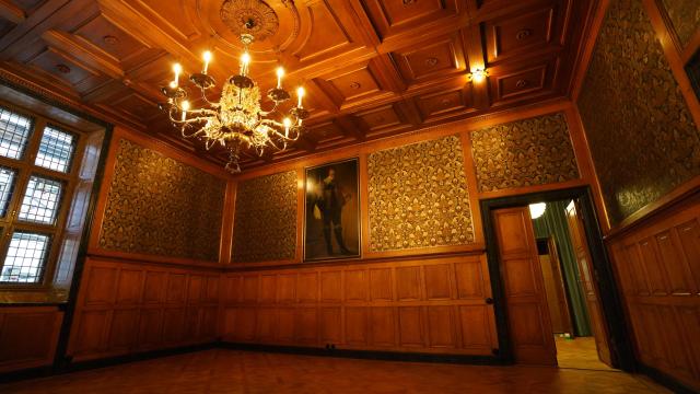 A painting of King Christian IV hangs in the reopened "Chairman’s Office" at Copenhagen's Old Stock Exchange "Boersen" building as reconstruction work is partly finished after the 2024 fire, in Copenhagen, Denmark, on December 18, 2025. Twenty months after a devastating fire, parts of Copenhagen’s 16th-century Old Stock Exchange have reopened to visitors on December 19, 2025. The historic former stock exchange building Boersen was severely damaged by a fire on April 16, 2024. (Photo by James BROOKS / AFP)