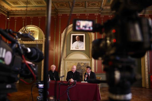 Archbishop-elect of Westminster Richard Moth (C) speaks next to Cardinal Vincent Nichols (L) under a portrait of Pope Leo XIV during a press conference in the Throne Room of Archbishop’s House in London on December 19, 2025. The Diocese of Westminster announced that Right Reverend Richard Moth has been appointed as Archbishop of Westminster, succeeding Cardinal Vincent Nichols, who has served in the role since 2009. (Photo by Henry NICHOLLS / AFP)