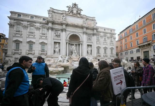 Tourists queue in front of the Trevi fountain in central Rome on December 19, 2025. (Photo by Filippo MONTEFORTE / AFP)
