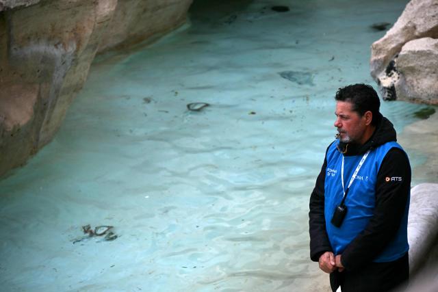 A security officer blows in his whistle at the entrance of the Trevi fountain in central Rome on December 19, 2025. (Photo by Filippo MONTEFORTE / AFP)