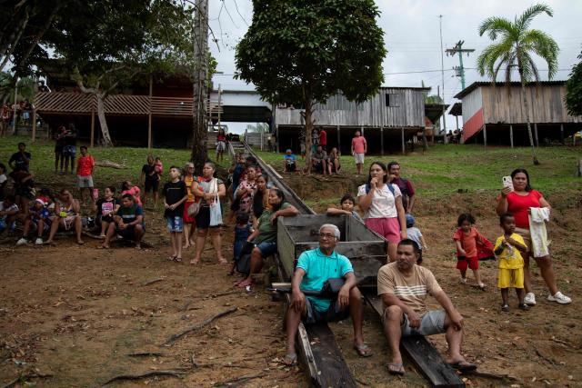 Riverine residents watch the arrival of a ferry decorated for Christmas in the community of Bela Vista do Jaraqui, on the Rio Negro, in the rural area of Manaus, Amazonas state, northern Brazil on December 18, 2025. ‘Natal nas Aguas’ (Christmas on the Waters) is an initiative that brings the magic of Christmas to riverside communities in hard-to-reach locations. (Photo by MICHAEL DANTAS / AFP)