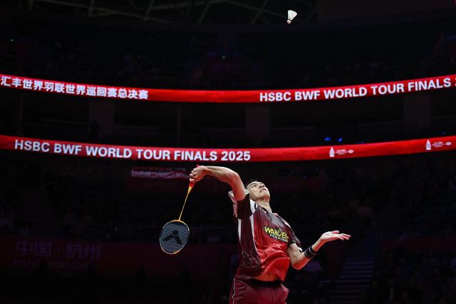 Indonesia’s Jonatan Christie hits a return to France’s Christo Popov during their men's singles match at the BWF Badminton World Tour Finals at the Hangzhou Olympic Sports Centre Gymnasium in Hangzhou, in eastern China's Zhejiang province on December 19, 2025. (Photo by Jade Gao / AFP)