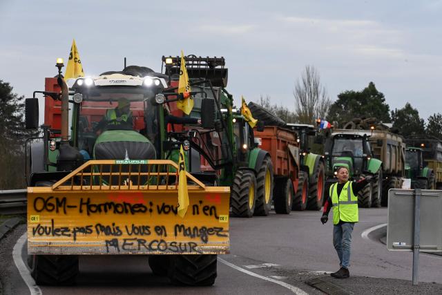 A Rural Coordination (CR) farmer gives instructions to farmers with tractors as they gather to protest against the EU-Mercosur deal that would create the world's biggest free-trade area, in Alencon, northern France on December 19, 2025. The signing of the trade deal was pushed back to January on December 18, 2025, after farmers staged a show of force against the pact outside a Brussels leaders' summit. (Photo by JEAN-FRANCOIS MONIER / AFP)