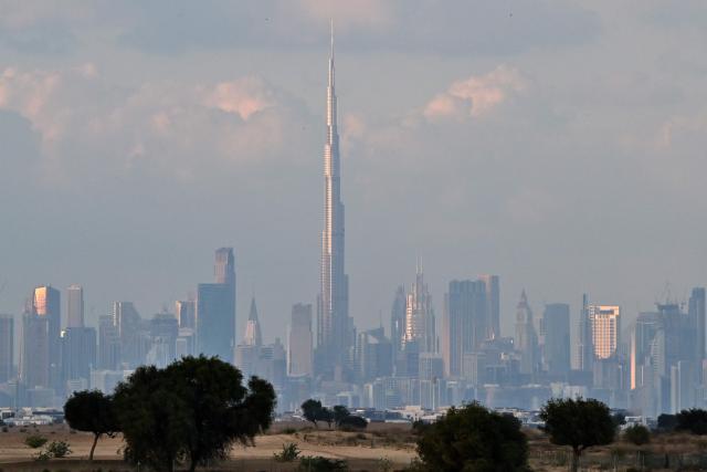 Clouds loom over the Dubai skyline including the Burj Khalifa, the world’s tallest building, in the United Arab Emirates on December 19, 2025. Dubai police urged residents on December 18, 2025, to stay indoors unless it was "absolutely necessary" as heavy rainfall was expected in the desert country which saw record downpours last year. (Photo by Giuseppe CACACE / AFP)
