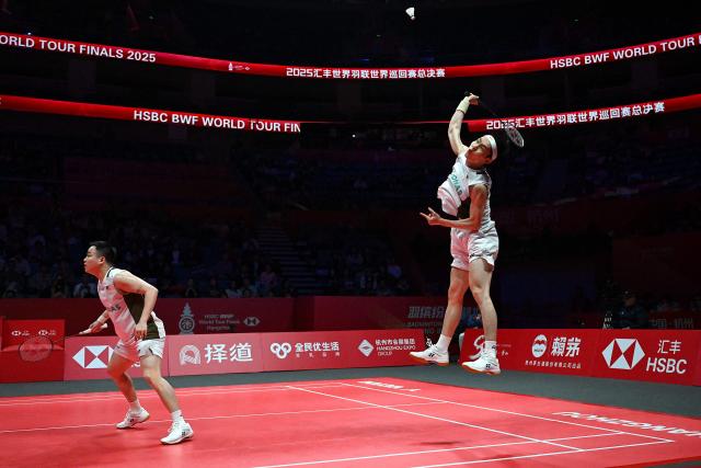 Malaysia’s Aaron Chia and Soh Wooi Yik play a point during their men’s doubles match against India’s Satwiksairaj Rankireddy and Chirag Shetty at the BWF Badminton World Tour Finals at the Hangzhou Olympic Sports Centre Gymnasium in Hangzhou, in eastern China's Zhejiang province on December 19, 2025. (Photo by Jade Gao / AFP)