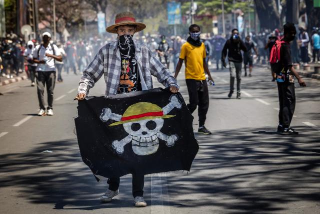 (FILES) (FILES) A student holds a flag bearing the logo of the popular Japanese manga One Piece, a symbol adopted by Gen Z protest movements worldwide, during clashes with Malagasy security forces amid a strike calling for constitutional reforms and the resignation of President Andry Rajoelina in Antananarivo, on October 9, 2025. (Photo by Luis TATO / AFP)