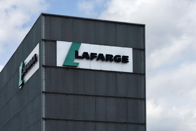 (FILES) This photograph shows the logo of the French industrial company Lafarge displayed on a building of a cement plant in northern Paris, on April 14, 2025. The Paris Correctional Court will deliver its verdict on April 13, 2026 in the trial for terrorism financing involving the company Lafarge and eight former executives, suspected of having paid jihadist groups classified as "terrorist" in Syria until 2014 to keep a cement plant operating there. (Photo by Sébastien DUPUY / AFP)
