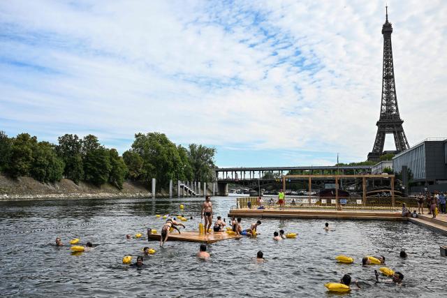 (FILES) People swim at the Grenelle safe bathing site on the Seine river on its opening day, in front of the Eiffel Tower in Paris on July 5, 2025. (Photo by JULIEN DE ROSA / AFP)
