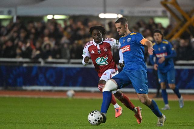 Avranches’ French midfielder #10 Jessy Pi (R)  fights for the ball with Brest’s Malian midfielder #08 Hamidou Makalou during the French Cup round of 64 football match between Avranches and Brest at Rene Fenouilere stadium in Avranches, on December 19, 2025. (Photo by DAMIEN MEYER / AFP)