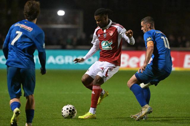 Avranches’ French defender #3 Pierre Bourdin (C) fights for the ball with Brest’s French forward #10 Romain Del Castillo (R) during the French Cup round of 64 football match between Avranches and Brest at Rene Fenouilere stadium in Avranches, on December 19, 2025. (Photo by DAMIEN MEYER / AFP)