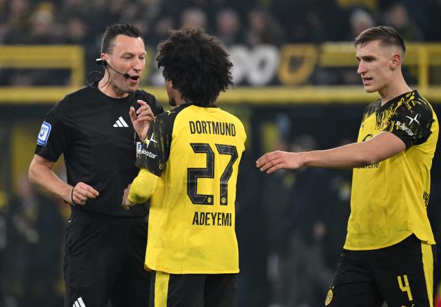 Dortmund's German forward #27 Karim Adeyemi discusses with referee Sven Jablonski during the German first division Bundesliga football match between Borussia Dortmund and Borussia Moenchengladbach in Dortmund on December 19, 2025. (Photo by UWE KRAFT / AFP) / DFL REGULATIONS PROHIBIT ANY USE OF PHOTOGRAPHS AS IMAGE SEQUENCES AND/OR QUASI-VIDEO