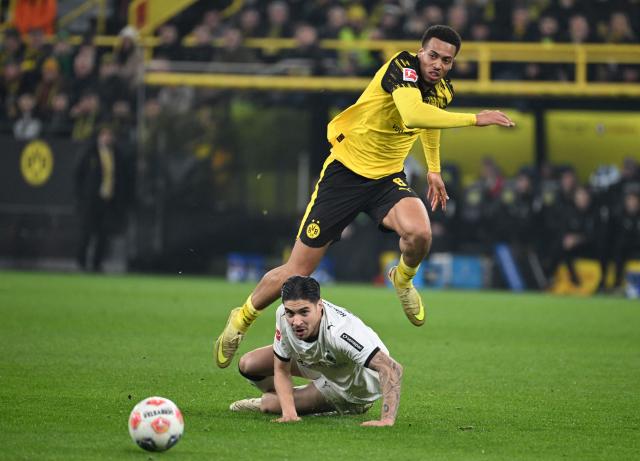 Moenchengladbach's Indonesian-Dutch defender #04 Kevin Diks and Dortmund's German midfielder #08 Felix Nmecha vie for the ball during the German first division Bundesliga football match between Borussia Dortmund and Borussia Moenchengladbach in Dortmund on December 19, 2025. (Photo by UWE KRAFT / AFP) / DFL REGULATIONS PROHIBIT ANY USE OF PHOTOGRAPHS AS IMAGE SEQUENCES AND/OR QUASI-VIDEO