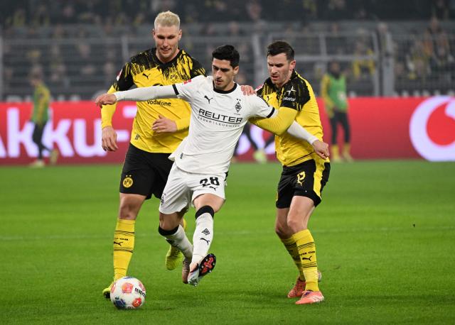 (L-R) Dortmund's German defender #25 Niklas Suele, Moenchengladbach's Armenian-German forward #28 Grant-Leon Ranos and Dortmund's German midfielder #13 Pascal Gross vie for the ball during the German first division Bundesliga football match between Borussia Dortmund and Borussia Moenchengladbach in Dortmund on December 19, 2025. (Photo by UWE KRAFT / AFP) / DFL REGULATIONS PROHIBIT ANY USE OF PHOTOGRAPHS AS IMAGE SEQUENCES AND/OR QUASI-VIDEO