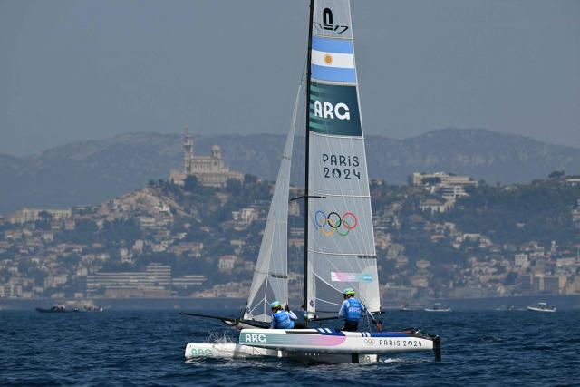 (FILES) Argentina's duo Mateo Majdalani and Eugenia Bosco compete in race 11 of the mixed Nacra 17 multihull event during the Paris 2024 Olympic Games sailing competition at the Roucas-Blanc Marina in Marseille on August 6, 2024. Argentina’s judiciary sentenced the former coach of Olympic sailing medalist Eugenia Bosco to six and a half years in prison for sexual abuse, a judicial source reported on December 19, 2025. (Photo by NICOLAS TUCAT / AFP)