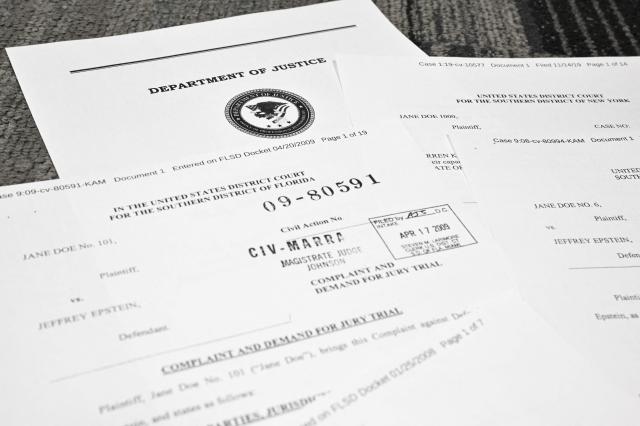 This photo illustration taken in Washington, DC, on December 19, 2025 shows court documents after the US Justice Department began releasing the long-awaited records from the investigation into the politically explosive case of convicted sex offender Jeffrey Epstein. (Photo by Mandel NGAN / AFP)