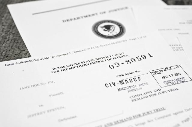 This photo illustration taken in Washington, DC, on December 19, 2025 shows court documents after the US Justice Department began releasing the long-awaited records from the investigation into the politically explosive case of convicted sex offender Jeffrey Epstein. (Photo by Mandel NGAN / AFP)