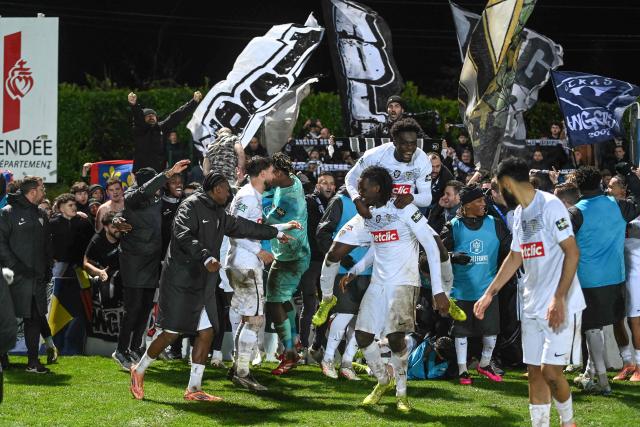 Angers' players celebrate after winning the French Cup round of 64 football match between Vendee Les Herbiers football and Angers SCO at the 'Massabielle' stadium in Les Herbiers, western France, on December 19, 2025. (Photo by JEAN-FRANCOIS MONIER / AFP)