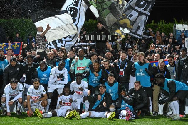 Angers' players celebrate after winning the French Cup round of 64 football match between Vendee Les Herbiers football and Angers SCO at the 'Massabielle' stadium in Les Herbiers, western France, on December 19, 2025. (Photo by JEAN-FRANCOIS MONIER / AFP)