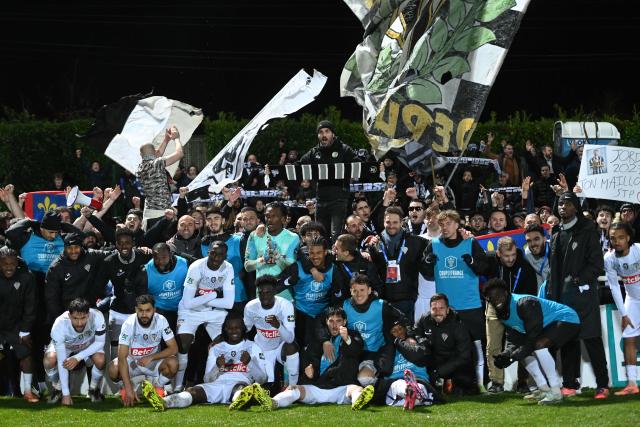 Angers' players celebrate after winning the French Cup round of 64 football match between Vendee Les Herbiers football and Angers SCO at the 'Massabielle' stadium in Les Herbiers, western France, on December 19, 2025. (Photo by JEAN-FRANCOIS MONIER / AFP)