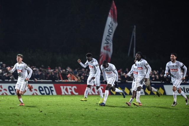 Angers' players celebrate the winning goal in a penalty shoot out during the French Cup round of 64 football match between Vendee Les Herbiers football and Angers SCO at the 'Massabielle' stadium in Les Herbiers, western France, on December 19, 2025. (Photo by JEAN-FRANCOIS MONIER / AFP)