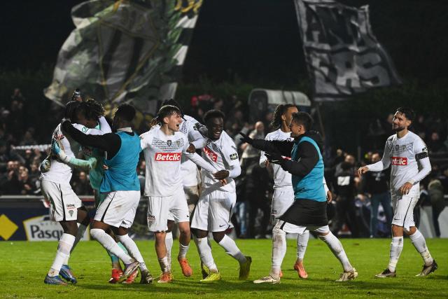 Angers' players celebrate after winning the French Cup round of 64 football match between Vendee Les Herbiers football and Angers SCO at the 'Massabielle' stadium in Les Herbiers, western France, on December 19, 2025. (Photo by JEAN-FRANCOIS MONIER / AFP)