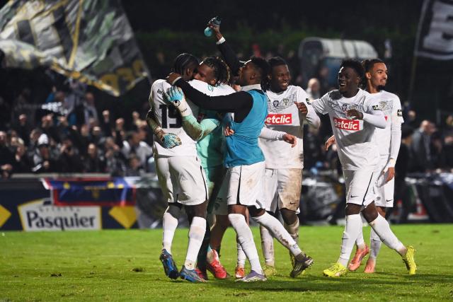 Angers' players celebrate after winning the French Cup round of 64 football match between Vendee Les Herbiers football and Angers SCO at the 'Massabielle' stadium in Les Herbiers, western France, on December 19, 2025. (Photo by JEAN-FRANCOIS MONIER / AFP)