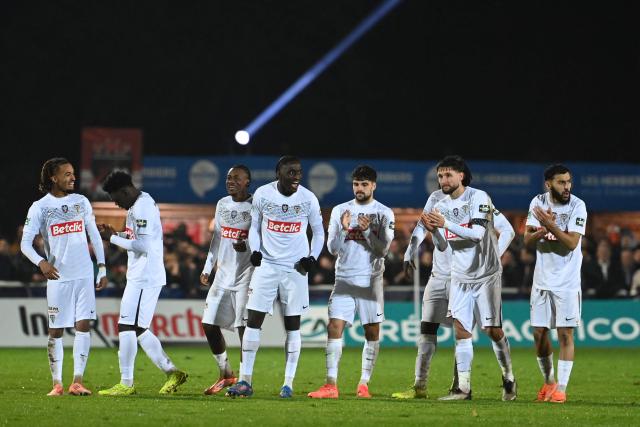 Angers' players celebrate after winning the French Cup round of 64 football match between Vendee Les Herbiers football and Angers SCO at the 'Massabielle' stadium in Les Herbiers, western France, on December 19, 2025. (Photo by JEAN-FRANCOIS MONIER / AFP)