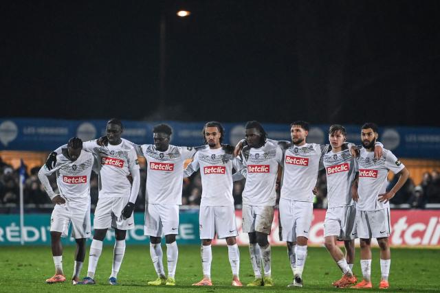 Angers' players react during a penalty shoot out  during the French Cup round of 64 football match between Vendee Les Herbiers football and Angers SCO at the 'Massabielle' stadium in Les Herbiers, western France, on December 19, 2025. (Photo by JEAN-FRANCOIS MONIER / AFP)