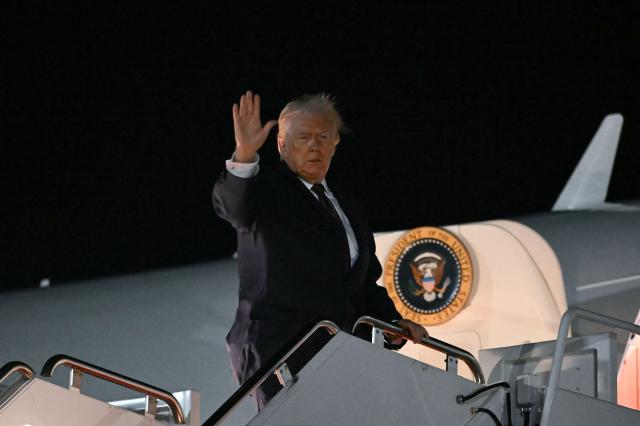 US President Donald Trump waves as he boards Air Force One as he departs from Joint Base Andrews, Maryland on December 19, 2025. Trump is on his way to Rocky Mount, North Carolina to hold a political rally and speak about the economy. (Photo by ANDREW CABALLERO-REYNOLDS / AFP)