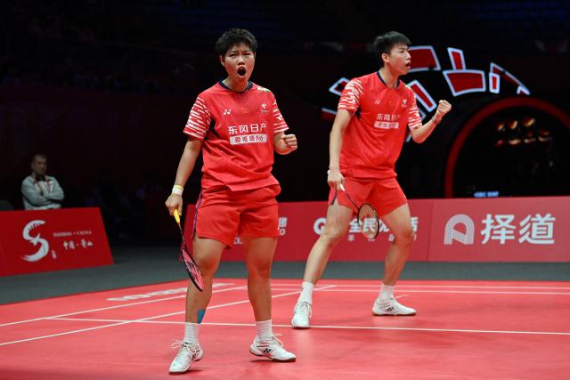 China’s Feng Yanzhe and Huang Dongping (L) react to winning  a point against Japan’s Hiroki Midorikawa and Natsu Saito during their mixed doubles semi-final match at the BWF Badminton World Tour Finals at the Hangzhou Olympic Sports Centre Gymnasium in Hangzhou, in eastern China's Zhejiang province on December 20, 2025. (Photo by Jade Gao / AFP)