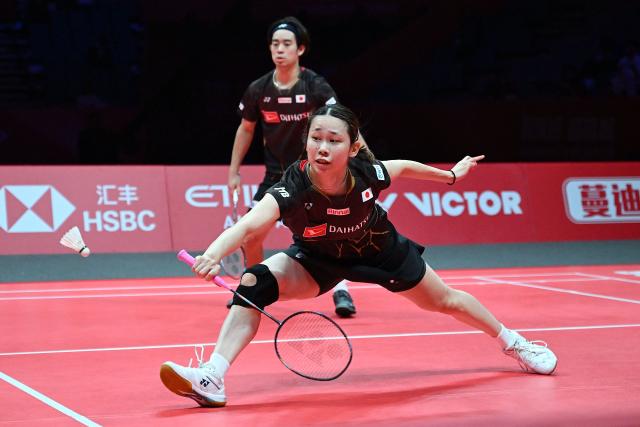 Japan’s Hiroki Midorikawa and Natsu Saito (R) play a point against China’s Feng Yanzhe and Huang Dongping during their mixed doubles semi-final match at the BWF Badminton World Tour Finals at the Hangzhou Olympic Sports Centre Gymnasium in Hangzhou, in eastern China's Zhejiang province on December 20, 2025. (Photo by Jade Gao / AFP)